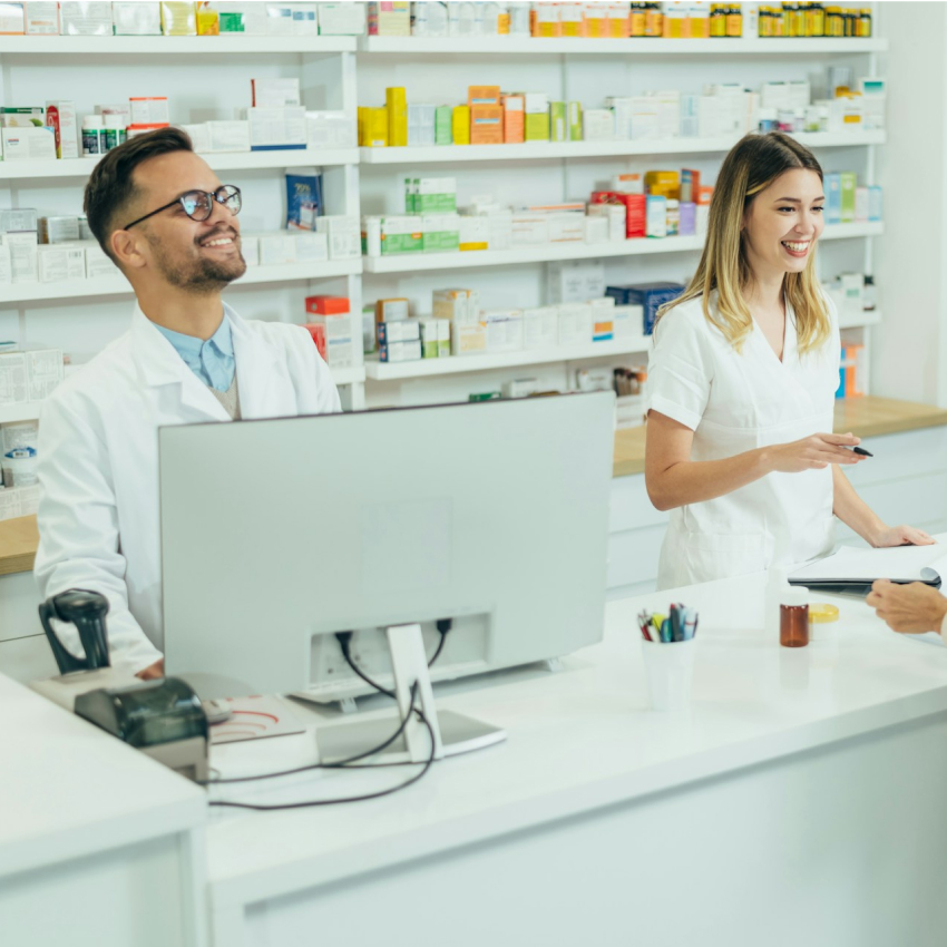 Two pharamcy employees helping a customer using software